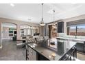 Bright kitchen showcasing a large island with seating, stainless steel appliances, and access to the outdoor living space at 2423 W Bramble Berry Ln, Phoenix, AZ 85085