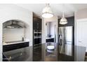 Modern kitchen with stainless steel appliances, dark cabinetry, black granite countertop and attractive white backsplash at 2423 W Bramble Berry Ln, Phoenix, AZ 85085