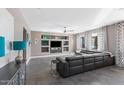 Spacious living room featuring a large sectional sofa, custom built-ins, and neutral color palette at 2423 W Bramble Berry Ln, Phoenix, AZ 85085