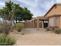 Backyard view displaying desert landscaping and a covered patio area attached to a sand-colored house at 3517 N Paseo Del Sol --, Mesa, AZ 85207