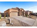 Single story home featuring a two car garage, driveway, and desert landscaping at 3517 N Paseo Del Sol --, Mesa, AZ 85207