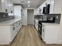 Modern kitchen featuring white cabinets, stainless steel appliances, and stylish backsplash at 3807 N 64Th Dr, Phoenix, AZ 85033