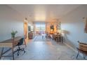 Bright living room featuring tile floors, a work space and a cozy seating area with balcony access at 4303 E Cactus Rd # 326, Phoenix, AZ 85032