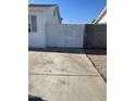 Concrete driveway leads to white wood fence and gate, and a block wall fence at 6607 W Osborn Rd, Phoenix, AZ 85033