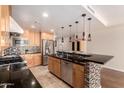 Gourmet kitchen with stainless steel appliances, a breakfast bar, and stylish pendant lighting at 6803 E Main St # 3306, Scottsdale, AZ 85251