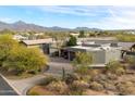 Aerial view of luxury home with desert landscaping and mountains in the background at 8845 E Sierra Pinta Dr, Scottsdale, AZ 85255