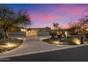 Stunning home exterior showcasing a gated entrance and meticulously landscaped front yard with pathway lighting at 8845 E Sierra Pinta Dr, Scottsdale, AZ 85255
