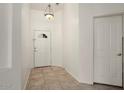 Bright entryway with neutral tile flooring, white walls, and a decorative light fixture, creating a welcoming first impression at 8962 W Grovers Ave, Peoria, AZ 85382