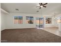 Spacious carpeted living room with large windows and sliding glass doors, offering ample natural light at 8962 W Grovers Ave, Peoria, AZ 85382