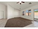 Comfortable carpeted living area with large windows, ceiling fan, and sliding glass door, enhancing its airy feel at 8962 W Grovers Ave, Peoria, AZ 85382