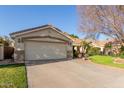 This home has a desert landscape, manicured lawn, and an attached two-car garage at 950 W Cooley Dr, Gilbert, AZ 85233