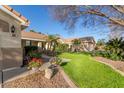 This lovely home features a lush lawn, desert landscaping, and charming curb appeal at 950 W Cooley Dr, Gilbert, AZ 85233