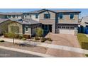 A charming two-story home with a brick driveway and two-car garage, enhanced by beautiful landscaping at 9960 E Strobe Ave, Mesa, AZ 85212