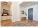 Bright foyer with hardwood floors, stylish rug, and a view of elegant decor and a paneled front door at 9960 E Strobe Ave, Mesa, AZ 85212