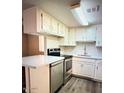 Kitchen featuring stainless steel appliances, white cabinets and countertop, and wood floors at 12221 W Bell Rd # 119, Surprise, AZ 85378