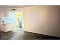 Living room featuring hardwood floors and view into the kitchen with stainless steel refrigerator at 12221 W Bell Rd # 119, Surprise, AZ 85378