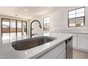 Close-up of modern kitchen featuring a stainless steel sink, quartz countertops, and stainless steel appliances at 12361 W Marguerite Ave, Avondale, AZ 85323