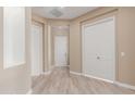 Hallway view showcases light tile floors and a neutral wall color scheme; the space is bright and has multiple doors and closets at 1474 E Elysian Pass, Queen Creek, AZ 85140