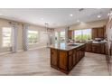 Open-concept kitchen featuring a large island, tile floors, and plenty of natural light at 1474 E Elysian Pass, Queen Creek, AZ 85140