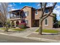Inviting two-story home featuring a covered balcony, porte-cochere, and manicured lawn at 15260 W Alexandria Way, Surprise, AZ 85379
