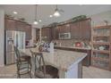 Spacious kitchen with granite countertops, stainless steel appliances, and dark wood cabinetry at 16763 W Adams St, Goodyear, AZ 85338
