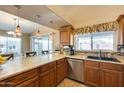 Stylish kitchen with stone countertops, wood cabinets, stainless steel appliances, and a breakfast bar at 17064 N Willow Path, Surprise, AZ 85374