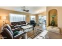 Cozy living room featuring tile flooring, a ceiling fan, comfortable seating, and lots of natural light at 17064 N Willow Path, Surprise, AZ 85374