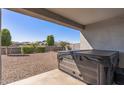 Covered outdoor patio featuring a hot tub for relaxation and a view of the backyard at 18369 W La Senda Dr, Surprise, AZ 85387
