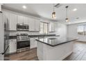 Modern kitchen boasts white cabinets, granite countertops, stainless steel appliances, and a spacious center island at 18369 W La Senda Dr, Surprise, AZ 85387