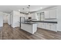 Modern white kitchen with an island, stainless steel appliances, and granite countertops at 18369 W La Senda Dr, Surprise, AZ 85387