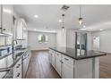 Bright kitchen features a large island, stainless steel sink, and wood-look floors, perfect for cooking and entertaining at 18369 W La Senda Dr, Surprise, AZ 85387
