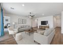 Bright living room with modern furnishings, ceiling fan, and wood-look tile flooring at 18369 W La Senda Dr, Surprise, AZ 85387