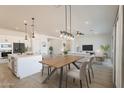 Open-concept dining area with modern lighting, stylish seating, and seamless flow to the living space at 20277 W Highland Ave, Litchfield Park, AZ 85340