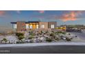 Desert home featuring a modern design with stacked stone accents, landscaped grounds, and a large garage at 26885 N 87Th Dr, Peoria, AZ 85383