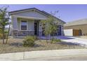 Well-maintained single-story home with a tidy front yard, rock landscaping and a dark two-car garage at 281 S San Gregorio Ln, Casa Grande, AZ 85194