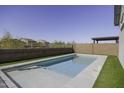 Sparkling in-ground swimming pool with artificial grass and a patio area, perfect for outdoor entertaining at 281 S San Gregorio Ln, Casa Grande, AZ 85194