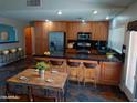 An open kitchen features stainless steel appliances, an eat-in island, and wood cabinets at 2901 W Straford Dr, Chandler, AZ 85224