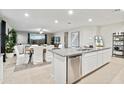 Open-concept kitchen featuring stainless steel appliances, island seating, and seamless integration with living spaces at 35961 W San Ildefanso Ave, Maricopa, AZ 85138