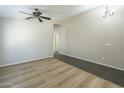 Open living area with wood floors, ceiling fan, and ample natural light at 36307 W El Greco St, Maricopa, AZ 85138