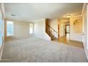 Bright living room with neutral walls, plush carpet, and staircase to second level at 3807 E Latham Ct, Gilbert, AZ 85297