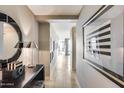 Elegant hallway featuring decorative art, stylish lighting, and a glimpse into the sunlit rooms beyond at 4808 N 24Th St # 1305, Phoenix, AZ 85016
