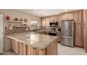Bright kitchen featuring a large island, stainless steel appliances and natural wood cabinets at 5910 N 86Th St, Scottsdale, AZ 85250