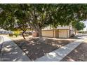 View of home with large shade tree and walkway at 6604 W Kingston Ln, Glendale, AZ 85306