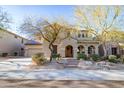 Charming two-story home with stone accents, arched entry, desert landscaping, and a three-car garage at 8362 W Rosewood Ln, Peoria, AZ 85383