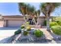 Charming home exterior featuring desert landscaping with mature yucca plants and decorative rock features at 9671 E Cavalry Dr, Scottsdale, AZ 85262