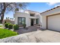 Contemporary home with a stucco exterior, red brick accents, desert landscaping, and a driveway at 10076 E Calle De Cielo E Cir, Scottsdale, AZ 85258