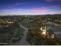 Aerial view of the community's lush landscaping, golf course, and resort-style pool at twilight at 10379 E White Feather Ln, Scottsdale, AZ 85262