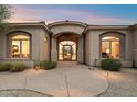 Elegant home featuring a beautifully arched entryway with stone accents at 10379 E White Feather Ln, Scottsdale, AZ 85262