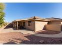 Wide shot of the private backyard, featuring a covered patio, desert landscaping, and privacy wall at 11034 E Natal Ave, Mesa, AZ 85209