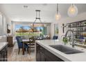 Bright, open-concept space featuring a kitchen island, dining area, and living area with a sliding glass door to the backyard at 11172 N San Clemente St, Surprise, AZ 85388